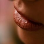 Detailed close-up of a woman's lips with glossy makeup finish.